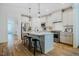 Bright kitchen features stainless appliances, white cabinets, an island with barstool seating, and wood floor at 151 Monteith Dr, Chapel Hill, NC 27516