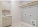 Bright laundry room with white cabinets, marble tile flooring, sink, and washer/dryer hookups at 151 Monteith Dr, Chapel Hill, NC 27516