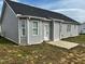 The backyard of the house with a concrete patio and simple landscaping and back entrance at 152 Springtooth Dr, Zebulon, NC 27597
