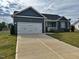 Inviting home with a two-car garage, manicured lawn, and charming front porch at 152 Springtooth Dr, Zebulon, NC 27597