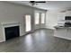 Open-concept living area with fireplace and large windows, flowing into modern kitchen at 152 Springtooth Dr, Zebulon, NC 27597