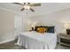 Bright bedroom with gray wood-look floors, ceiling fan, and a white door at 159 Mitchell Manor Dr, Angier, NC 27501
