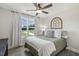 Sun-filled bedroom featuring a window, ceiling fan, wood floors, and comfortable bed at 159 Mitchell Manor Dr, Angier, NC 27501
