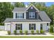 Charming two-story home featuring a white facade, black shutters, and a well-manicured lawn with an American flag at 159 Mitchell Manor Dr, Angier, NC 27501
