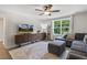 Living room featuring a gray sectional sofa, an ottoman, a large TV, and gray wood-look floors at 159 Mitchell Manor Dr, Angier, NC 27501