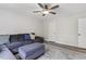 Living room featuring a gray sectional sofa, an ottoman, and gray wood-look floors at 159 Mitchell Manor Dr, Angier, NC 27501