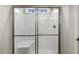 Walk-in shower with seat, glass doors, tile, and a window letting in natural light at 159 Mitchell Manor Dr, Angier, NC 27501