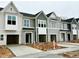 New construction townhomes show attached garages and concrete driveways on an overcast day at 166 Ripple Way # 323, Clayton, NC 27520