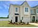 Charming two-story townhome with a one-car garage, black front door, and beautifully landscaped front yard at 174 Ripple Way # 324, Clayton, NC 27520
