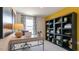 Bright office space with desk, chair, and a large shelving unit against a bright yellow accent wall at 177 Holton St, Smithfield, NC 27577