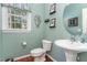 Charming powder room featuring updated fixtures, pedestal sink, decorative mirror, and natural light from a large window at 1952 Combine Cir, Apex, NC 27502