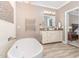 Bright and airy bathroom featuring a soaking tub, modern vanity, heated towel rack, and tile flooring at 1952 Combine Cir, Apex, NC 27502