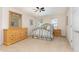 Cozy bedroom with neutral tones, a ceiling fan, dresser, and a wrought iron bed frame creating a relaxing ambiance at 1952 Combine Cir, Apex, NC 27502