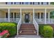 Welcoming front porch with elegant columns, brick steps, and charming landscaping at 1952 Combine Cir, Apex, NC 27502