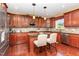 Well-appointed kitchen with cherry cabinetry, granite counters, tiled backsplash, stainless appliances, and a center island with counter seating at 1952 Combine Cir, Apex, NC 27502