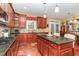 Gourmet kitchen with granite countertops, stainless appliances, and cherry cabinets; open floor plan to the breakfast and dining area at 1952 Combine Cir, Apex, NC 27502