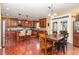 Spacious kitchen featuring cherry cabinetry, stainless appliances, granite counters, and a dining area with access to outdoor spaces at 1952 Combine Cir, Apex, NC 27502