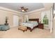 Elegant main bedroom with tray ceiling, ceiling fan, large windows with natural light, ensuite bathroom with a barn door entry at 1952 Combine Cir, Apex, NC 27502