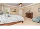 Spacious main bedroom with tray ceiling, ceiling fan, large window, sitting area, and a decorative dresser at 1952 Combine Cir, Apex, NC 27502