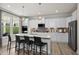 Modern kitchen with white cabinets, stainless steel appliances, an island with bar stools and elegant pendant lighting at 199 Sugar Pine Drive, Franklinton, NC 27525