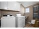 Well-organized laundry room featuring a front-load washer and dryer, overhead storage, and a utility sink at 199 Sugar Pine Drive, Franklinton, NC 27525