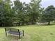 Serene backyard with a bench overlooking a pond, ideal for enjoying nature at 210 Standish Dr Dr, Chapel Hill, NC 27517