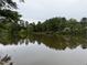 Scenic view of a house on the lakefront surrounded by lush trees, offering a tranquil setting at 210 Standish Dr Dr, Chapel Hill, NC 27517
