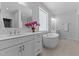 Bright bathroom featuring double sinks, soaking tub, and large mirror at 236 Artisan Park Dr, Wake Forest, NC 27587