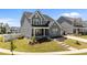 Beautiful gray home with a covered porch, landscaped yard, and a paved walkway leading to the entrance at 236 Artisan Park Dr, Wake Forest, NC 27587