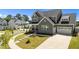 Attractive gray home with neat landscaping, front porch, long driveway and a two-car garage in a lovely neighborhood at 236 Artisan Park Dr, Wake Forest, NC 27587