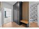 Hallway with large black storage cabinet, bench, and patterned wallpaper in the adjacent bathroom at 236 Artisan Park Dr, Wake Forest, NC 27587