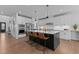 Contemporary kitchen featuring a large island with seating, white cabinets, and stainless steel appliances at 236 Artisan Park Dr, Wake Forest, NC 27587