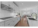 Bright, modern kitchen with white cabinets, stainless steel range hood, and view into the dining room at 236 Artisan Park Dr, Wake Forest, NC 27587