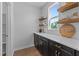 Pantry with black cabinets, white countertops, wooden shelves, and stylish decor at 236 Artisan Park Dr, Wake Forest, NC 27587