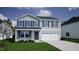 Charming two-story home featuring a well-manicured lawn and a two-car garage at 24 Grove Township Way, Angier, NC 27501