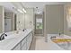 Bathroom featuring dual sink vanity, garden tub, and natural light at 25 Ballinger Dr, Youngsville, NC 27596