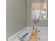 Relaxing bath featuring a soaking tub, window, and tray holding wine and a glass at 25 Ballinger Dr, Youngsville, NC 27596