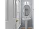 Quaint half bathroom with a pedestal sink and a window for natural light at 25 Ballinger Dr, Youngsville, NC 27596