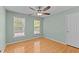 Cozy bedroom with hardwood floors, ceiling fan, and two sunny windows at 25 Ballinger Dr, Youngsville, NC 27596