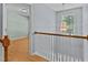 Upstairs hallway landing with hardwood floors and decorative lighting at 25 Ballinger Dr, Youngsville, NC 27596