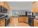 Well-lit kitchen with stainless steel appliances, solid countertops, and wood cabinets at 25 Ballinger Dr, Youngsville, NC 27596