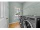 Bright laundry room with washer, dryer, shelving, and natural light at 25 Ballinger Dr, Youngsville, NC 27596