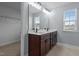 Bathroom with a double vanity and a view into a walk-in closet at 25 Gallery Park Dr, Franklinton, NC 27525