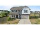 Charming two-story home with stone accents, manicured lawn, and attached garage at 25 Gallery Park Dr, Franklinton, NC 27525