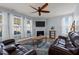 Comfortable living room with a fireplace, ceiling fan, leather furniture, and large windows at 25 Gallery Park Dr, Franklinton, NC 27525