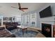 Open-concept living room boasts a fireplace, ceiling fan, and seamless flow into the modern kitchen and dining area at 25 Gallery Park Dr, Franklinton, NC 27525