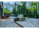 A large stone patio, outdoor oven, and in-ground pool in a tree-lined backyard at 2511 Bexley Ave, Durham, NC 27707