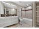 Well-lit bathroom featuring double vanity, tiled floor, marble tile accents and shelf storage at 2511 Bexley Ave, Durham, NC 27707