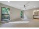 Spacious bedroom with carpet, fan, and windows, leading to an en-suite bathroom at 2511 Bexley Ave, Durham, NC 27707