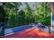 A spacious, wooden deck overlooks a lush, green backyard with a swimming pool at 2511 Bexley Ave, Durham, NC 27707